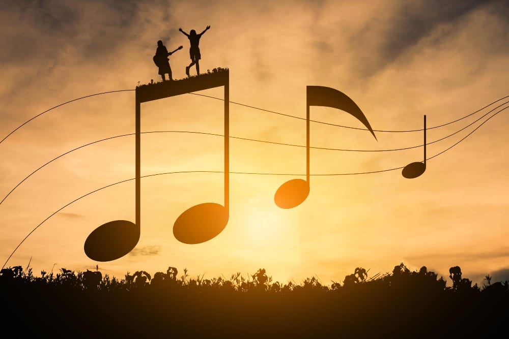 Silhouetted musical notes against a golden sunset, with two figures playing guitar and cheering on top of a note.